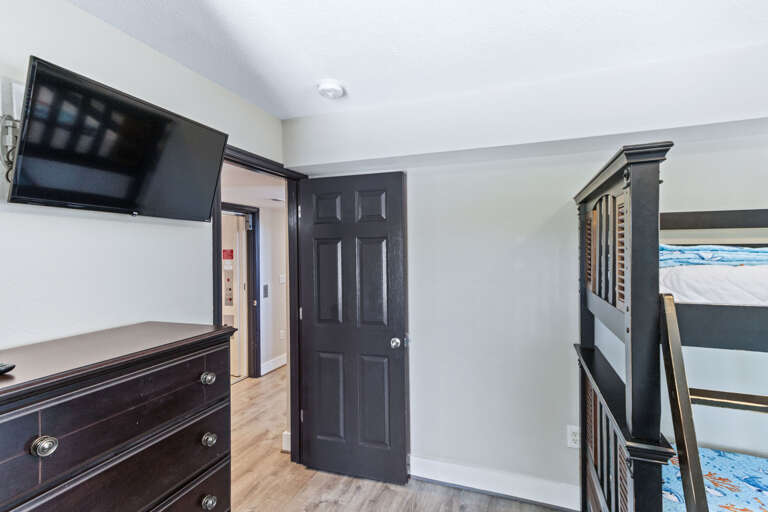 This ground floor bunk room has a full-sized bed and twin bunk large closet with a tall chest of drawers and Smart -TV.