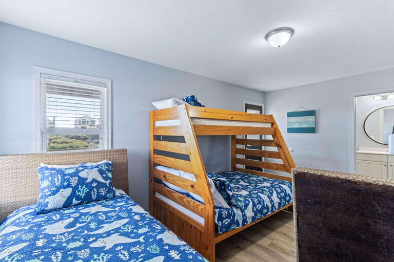 Located on the mid level just off the den, this bunk room has a full sized bed and 3 twins.