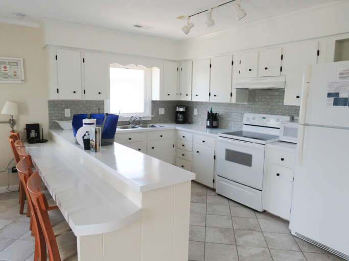 Bright Kitchen Interior With White Appliances And Cabinets