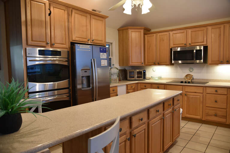 Spacious Kitchen With Wooden Cabinets And Stainless Steel Appliances In A Vacation Rental