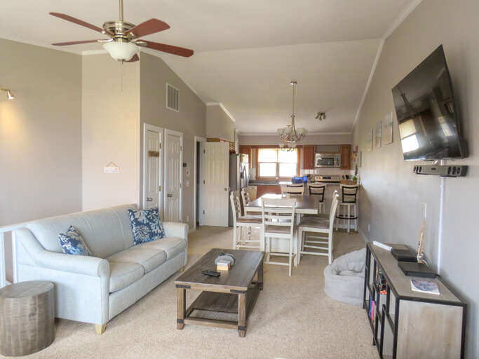 Living Room Interior With Sofa, Coffee Table, Television, And Kitchen Area Living Room Interior With Sofa, Coffee Table, Television, And Kitchen Area