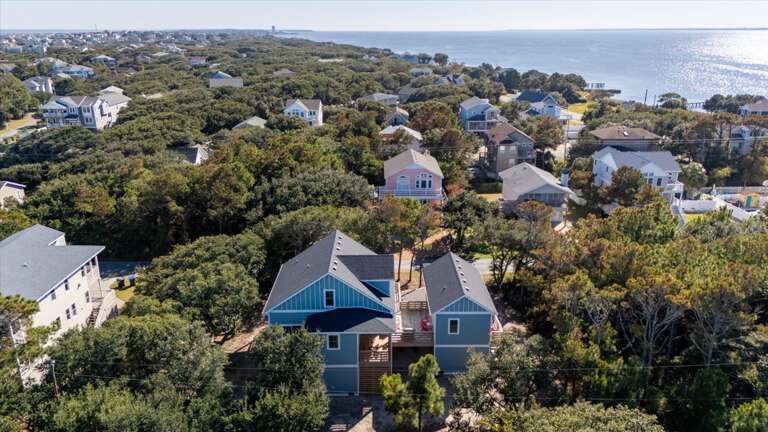 Aerial View Of Seaside Settlement Surrounded By Greenery