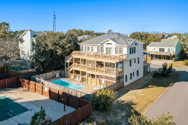 Spacious Structure Surrounded By Serene Scenery, Featuring Fenced Pool And Multiple Balconies