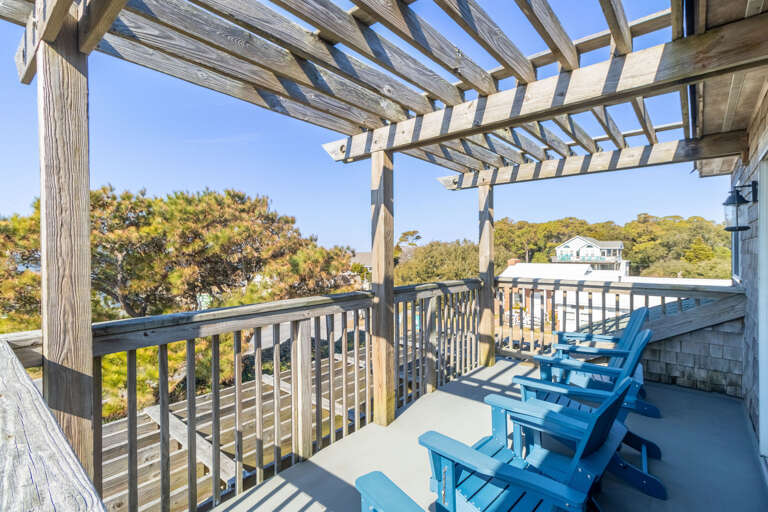 Balcony With Blue Chairs, Overlooking Greenery And Wooden Pergola Above