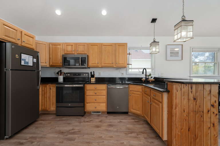 Well-appointed kitchen featuring granite countertops, upgraded appliances, and a breakfast bar, ideal for preparing home-cooked meals. 
