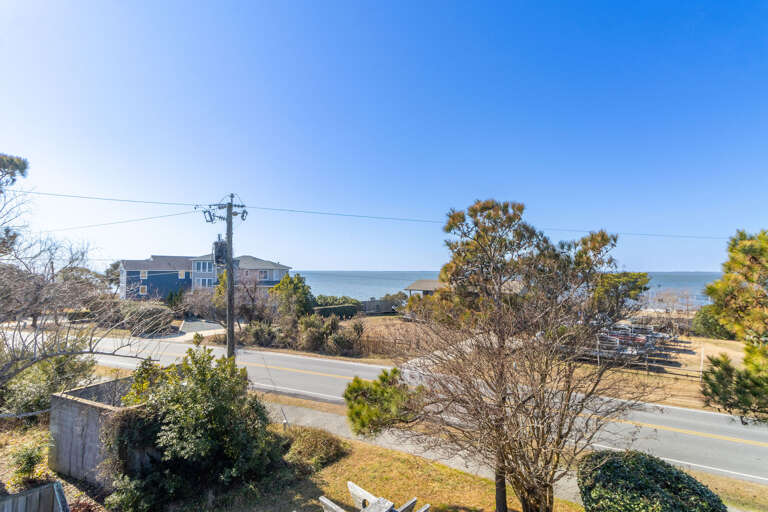 Seaside Scene Showing Shoreline Shrubs, Sunlit Sky, Sandy Stretches, Serpentine Street