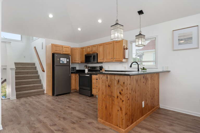 Well-appointed kitchen featuring granite countertops, upgraded appliances, and a breakfast bar, ideal for preparing home-cooked meals. 
