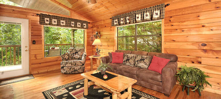 Rustic Relaxation: Pine-paneled Living Space, Plush Seating, Light-filled Ambiance