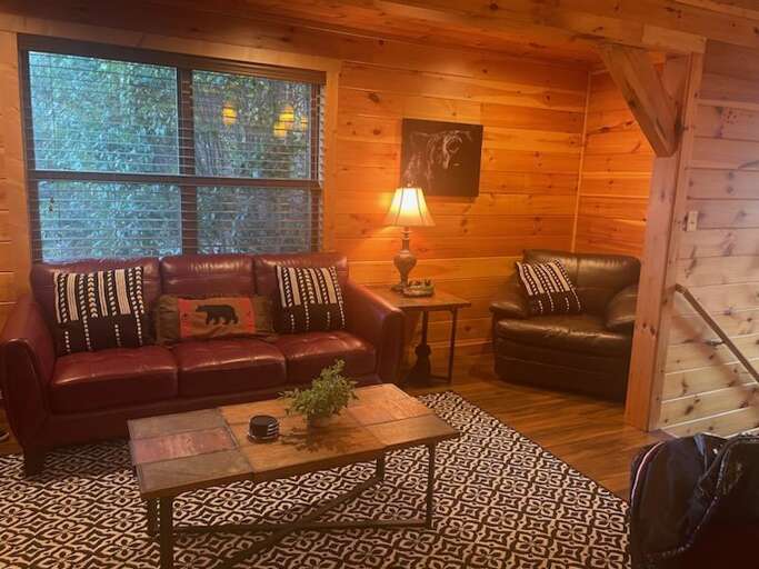 Rustic Room With Red Sofa, Wooden Walls, And Large Windows