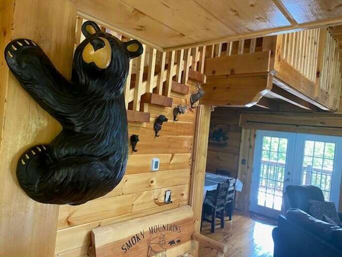 Bear Sculpture Beside Wooden Staircase, Sunlit Space With Seats