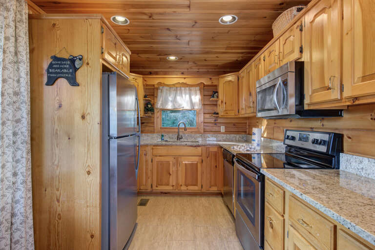 Wooden-walled Kitchen With Stainless Steel Appliances And Granite Countertops
