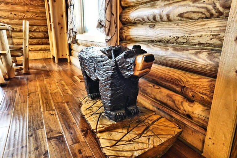 Wooden Bear Sculpture In Cabin Corner