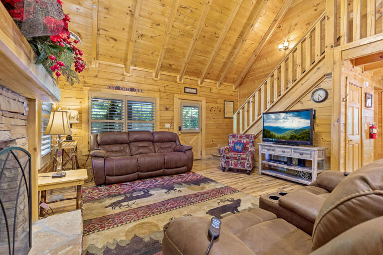 Rustic Room With Wood Walls, Plush Seating, And Stone Fireplace