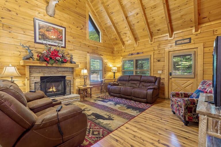 Log Living Space With Soaring Ceiling, Snug Sofas, And Blazing Fireplace