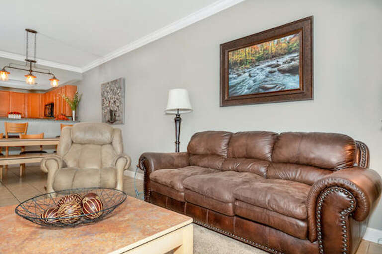 Interior Living Space With Leather Sofa, Chair, And Landscape Painting