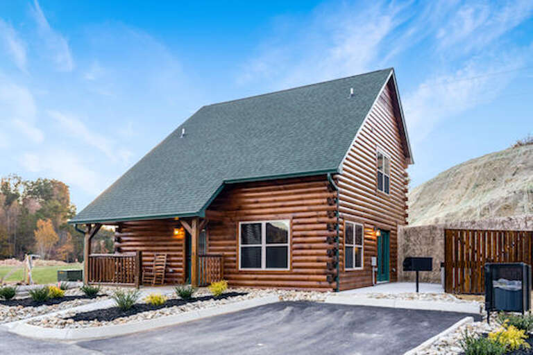 Log Cabin With Paved Driveway In Pastoral Setting