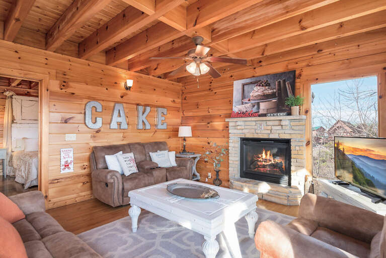 Living Room With Large Wooden Walls, Fireplace, And CAKE Sign