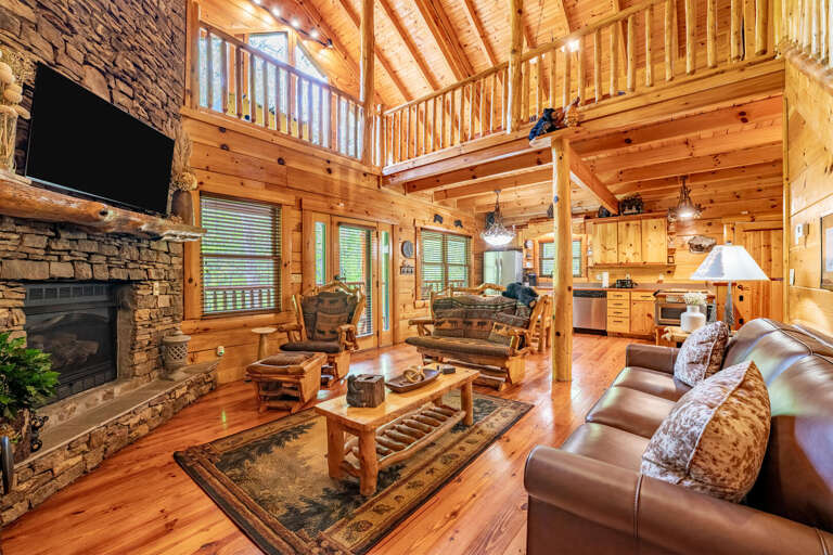 Log Living Space With Lofty Loft, Leather Sofas, Stone Fireplace