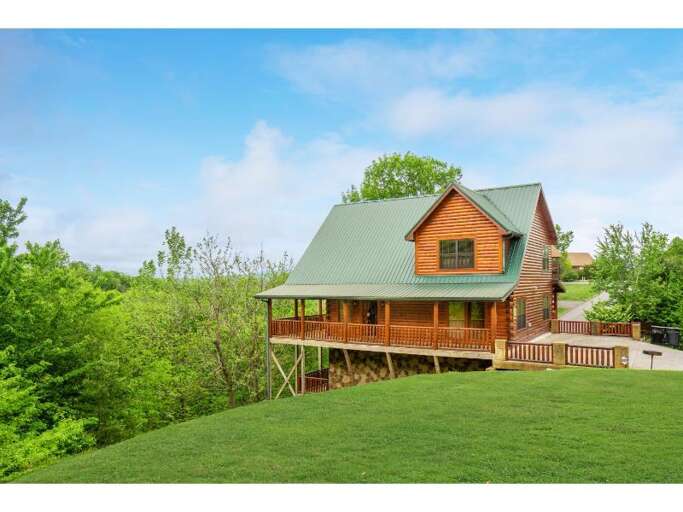 Wooden House On Grassy Hill With Vibrant Greenery