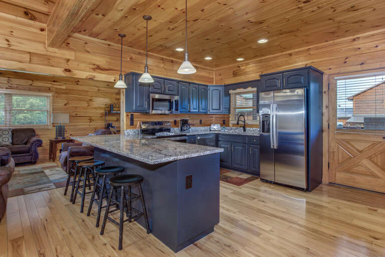 Spacious Kitchen With Sleek Steel Appliances Surrounded By Smooth Wooden Walls And Floors