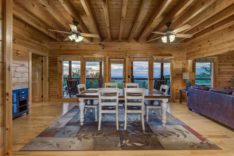 Wooden Vacation Rental Interior With Dining Area, Sofas, And Scenic Windows