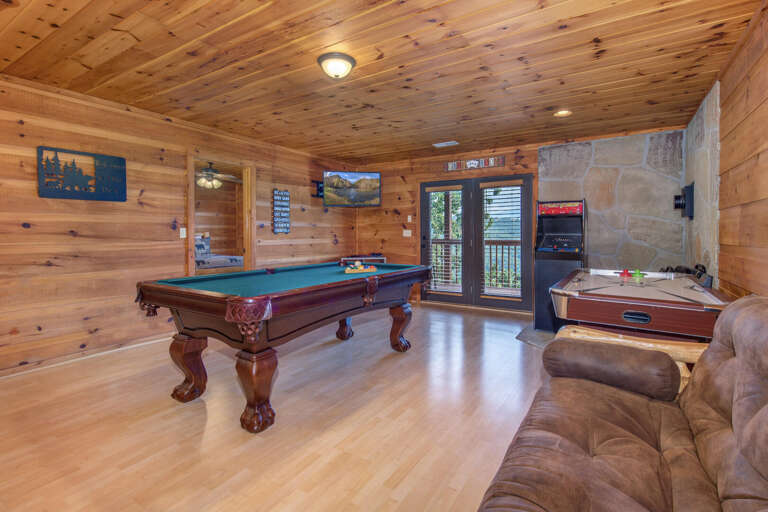 Wood-paneled Room With Pool Table And Plush Seating, Sliding Door Leading To Outside