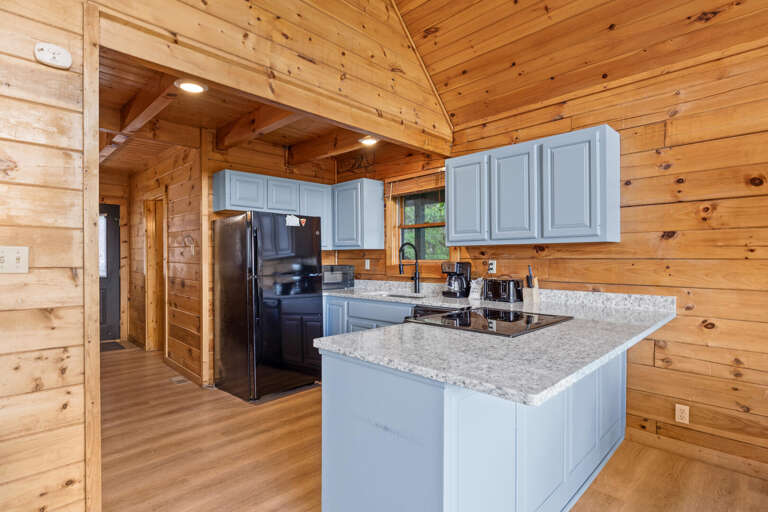 Wood-lined Kitchen With Blue Cabinets And Stainless Steel Appliances