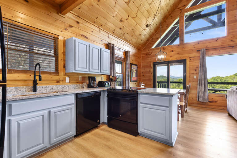 Vacation Rental Kitchen With Wooden Walls, High Ceilings, And Hillside Views