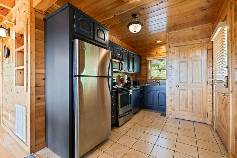 Wood-lined Kitchen With Stainless Steel Appliances And Tiled Floor