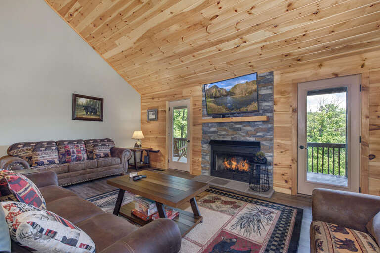 Rustic Living Room With Wooden Walls, Stone Fireplace, And Pastoral Paintings