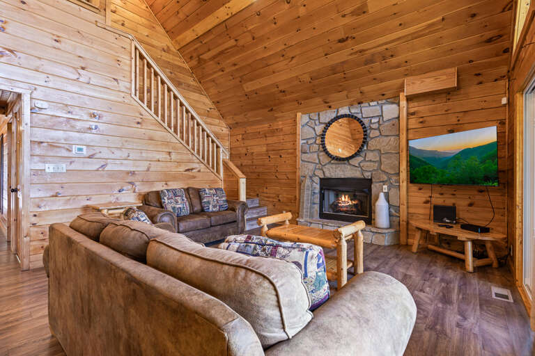 Rustic Room With Stone Fireplace, Wooden Walls, And Plush Sofa