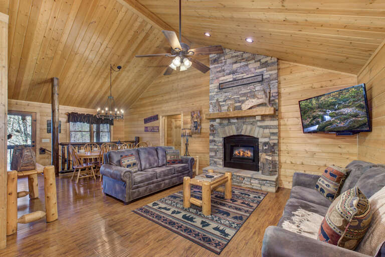 Wood-lined Living Space With Stone Fireplace And Plush Seating