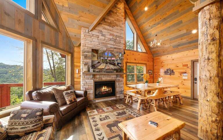 Wood-lined Living Space With Stone Fireplace And Forest Views