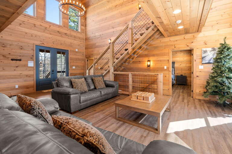 Vacation Rental Interior With Wooden Walls And Floors, Furnished With Sofas And A Staircase