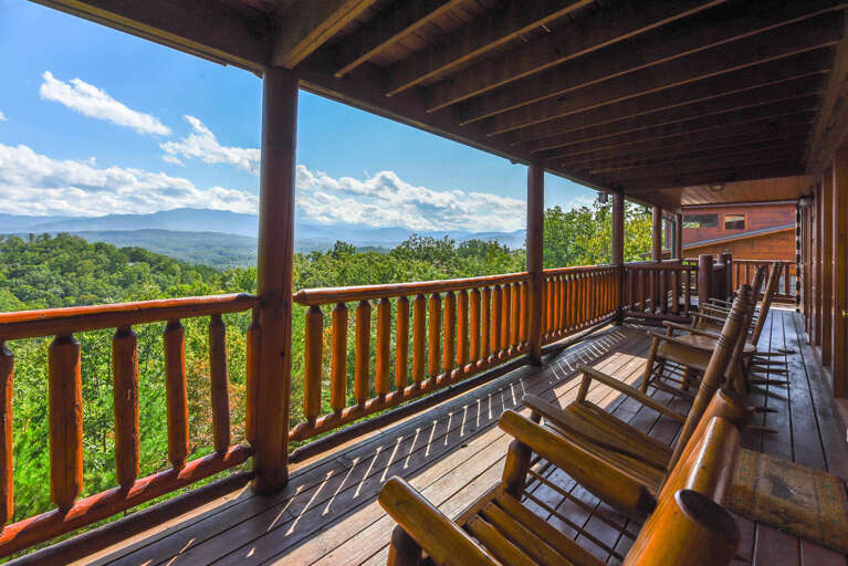 Vacation Rental Balcony With Wooden Chairs Overlooking Verdant Valley Vista