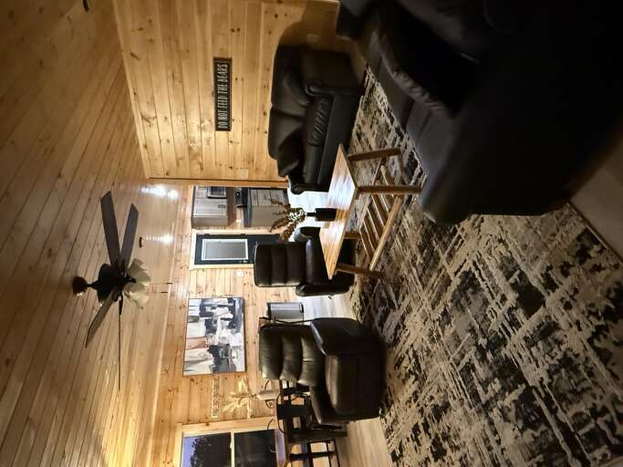 Wooden Walls With Black Leather Furniture And Patterned Rug In Indoor Lounge Area