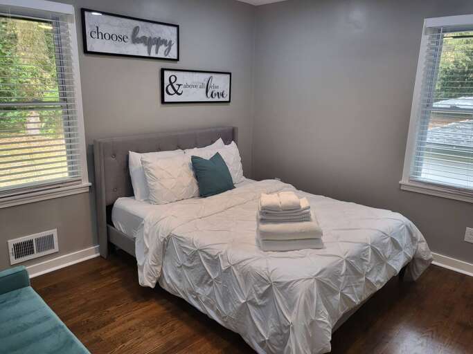 Bedroom With Bed, Linens, And Decorative Signs