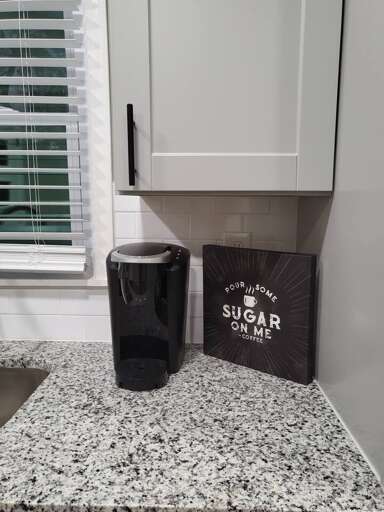 Kitchen Countertop With A Black Coffee Mug And A Decorative Sugar Container