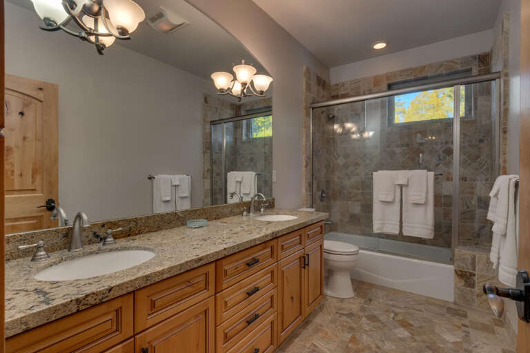 Bathroom with dual sinks and glass enclosed shower