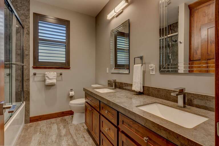Bathroom with dual sinks and full bath and shower combo