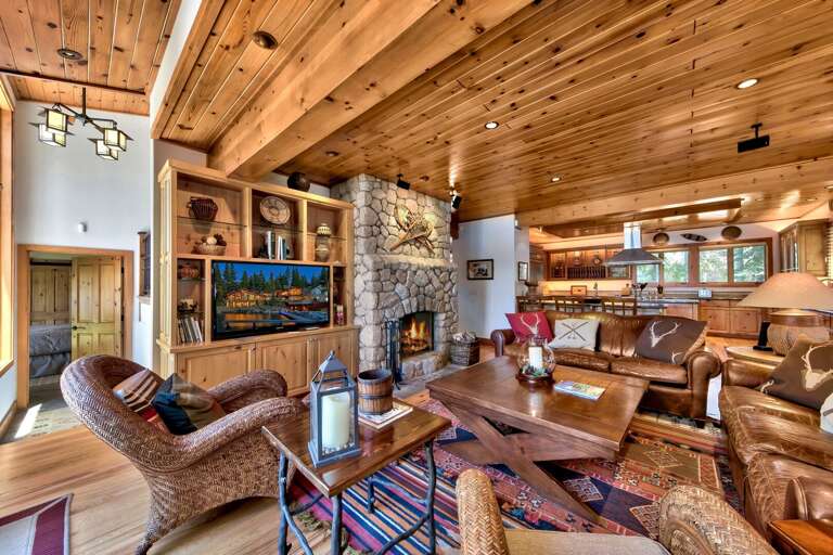Living area with comfy sofa, flat screen tv, and stone encased fireplace