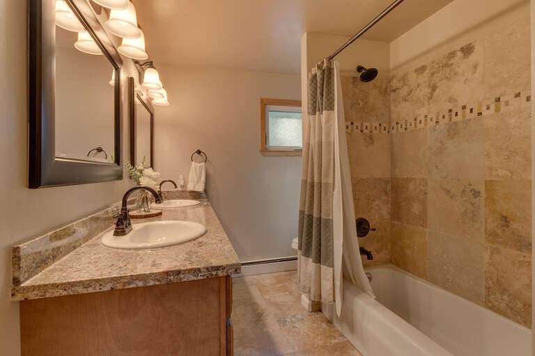 Bathroom with dual sinks and full bath and shower combo