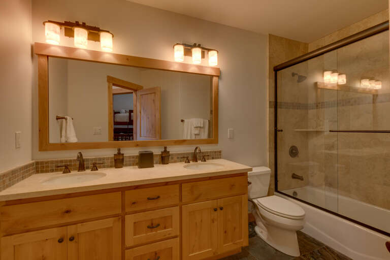 Bathroom with dual sinks and full bath and shower combo
