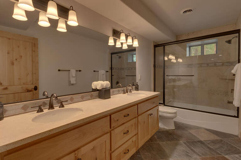 Bathroom with dual sinks and full bath and shower combo