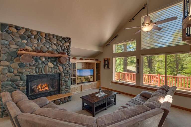 Living area with large sofa, flat screen tv, and fireplace