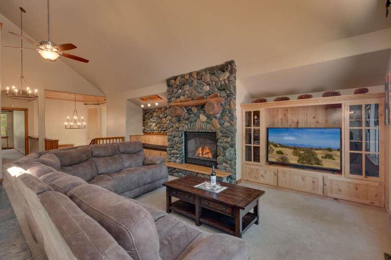 Living area with large sofa, flat screen tv, and fireplace