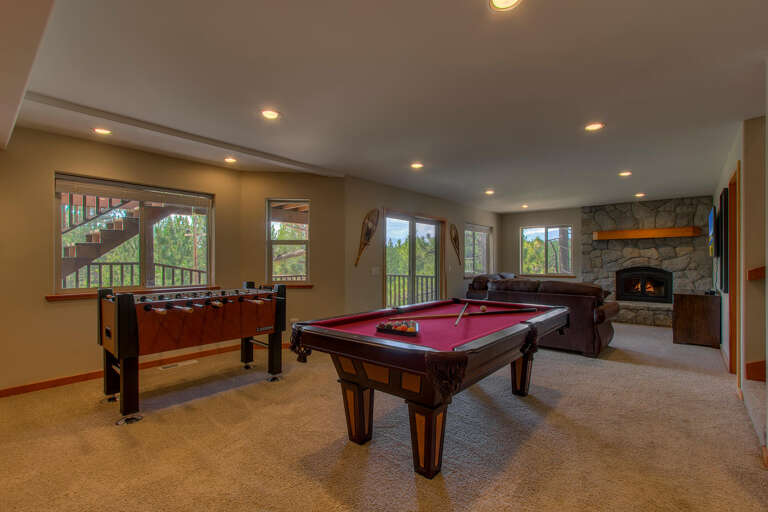 Game room with pool table, foosball, arcade, comfy couch, and fireplace