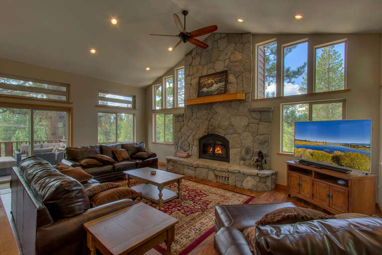 Living area with large couch, flat screen tv, and fireplace