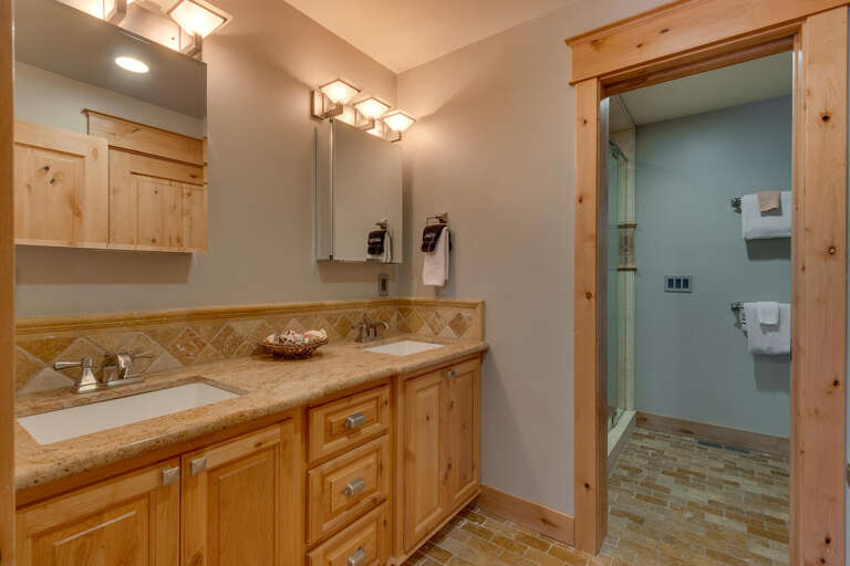 Bathroom with dual sinks and glass enclosed shower