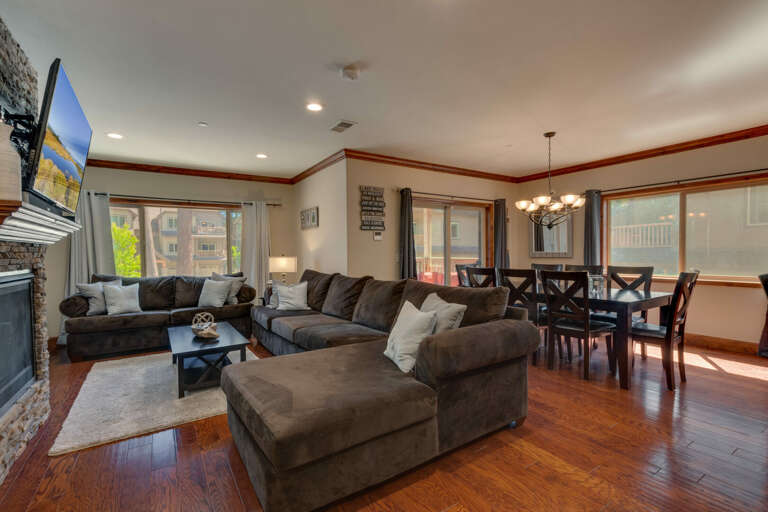 Living area with comfy sectional sofa, flat screen tv, fireplace, and shuffleboard
